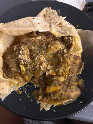 Goat Roti - Tender curry goat wrapped in soft, flaky roti bread with potatoes and chickpeas